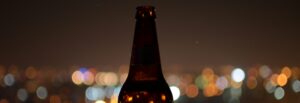 Silhouette of a bottle in front of a night skyline