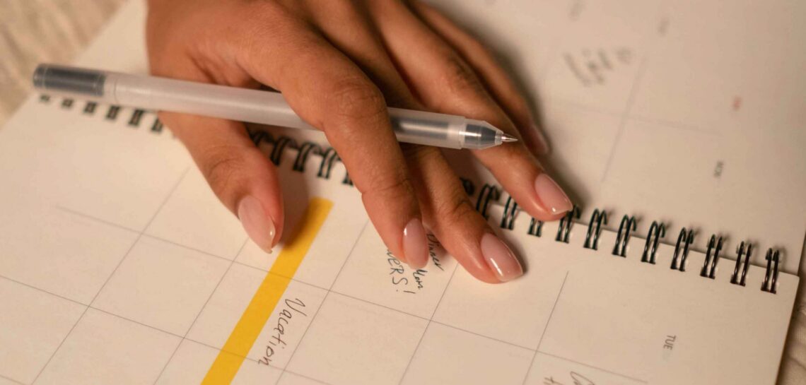 hands search through a date planner to find time for an appointment