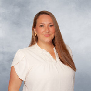 Alicia poses for photo, in front of a heathered periwinkle backdrop.